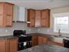 Kitchen.  Notice the full wall ceramic tiling and the slim stainless steel range hood.